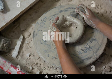Hands of girl using sponge while molding a clay Stock Photo