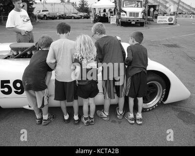 Kids gawking at race car at track in New York state Stock Photo