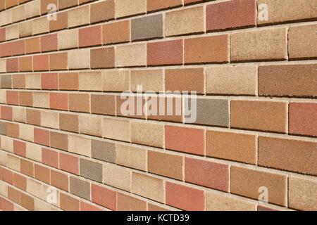 Attractive modern brick wall background with varying shades of light brown colored bricks in traditional design. Stock Photo