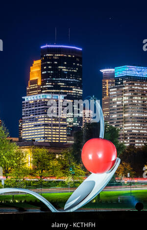 Spoonbridge and Cherry sculpture in front of Minneapolis skyline at nightt. Designed by Claes Oldenburg and his wife, Coosje van Bruggen. The complex  Stock Photo