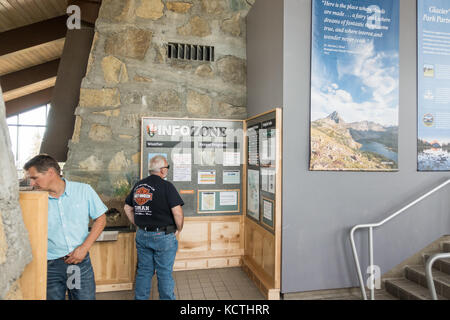 Men looking at / reading information boards at the Logan Pass Visitor Center, Glacier NP Stock Photo