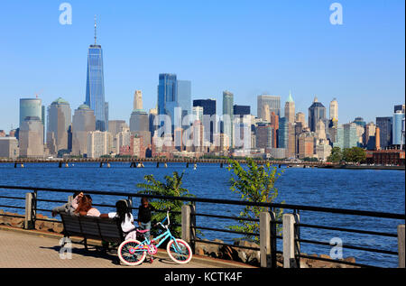 Visitors relaxing on the Hudson River Waterfront Walkway with skyline of Lower Manhattan in background.New York City/New Jersey,USA Stock Photo