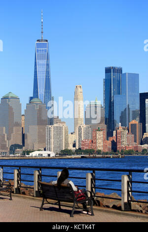 Visitors relaxing on the Hudson River Waterfront Walkway with skyline of Lower Manhattan in background.New York City/New Jersey,USA Stock Photo