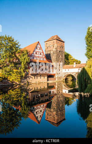 Hangman’s Tower (Henkerturm) and traditional medieval half-timbered (fachwerk) house over the river Pegnitz in Nuremberg, Germany Stock Photo