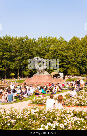 Warsaw, Poland - September 11, 2016: People enjoying open-air piano concert near Frederic Chopin monument in Royal Lazienki park (Royal Baths park), W Stock Photo