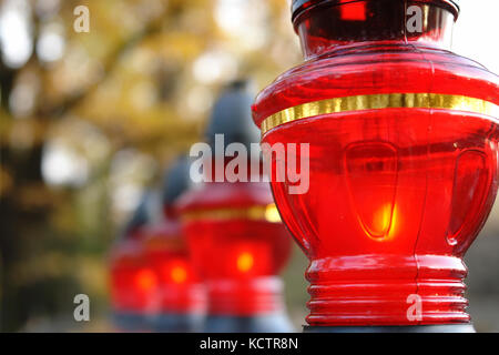 Closeup of red votive candles lit on tombstone Stock Photo