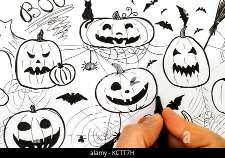 Woman hand with black pen drawing Halloween concept. Stock Photo