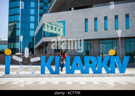 Students of National University of Kharkiv pose against the 'I Kharkiv' letters in Freedom Square, Kharkiv, Ukraine Stock Photo