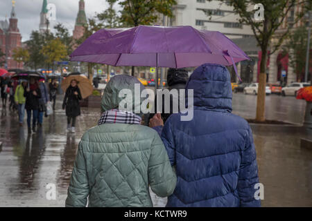 People walk under an umbrella on a Tverskaya street in Moscow during a rain Stock Photo