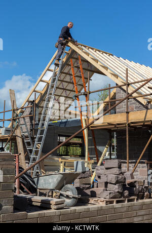 Man roofing on newbuild house, Abergavenny, Wales, UK Stock Photo