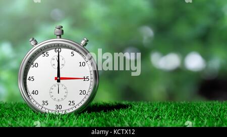 Silver chronometer on green grass Stock Photo