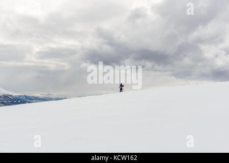 Picture is taken on a hike up Kjølen (mountain). Lonely skier in open white winter landscape. Kvaløya, Tromsø, Norway. Stock Photo