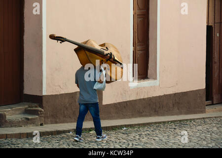 Man carrying a Double bass, Trinidad,  Cuba Stock Photo