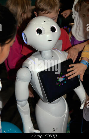 Children interacting with Pepper, a humanoid social robot,  in the Robot Zone at New Scientist Live 2017 Stock Photo