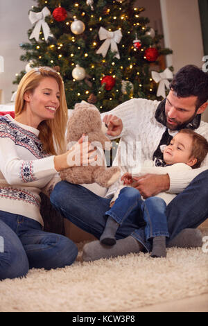happy smiling Christmas  family playing with bear Stock Photo