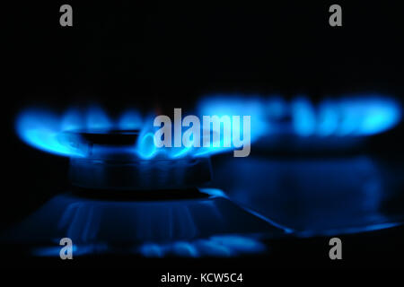 Closeup of two gas cooker burners lit in the darkness Stock Photo