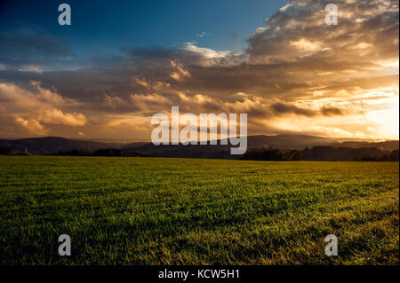 end of day on green field with sunset Stock Photo