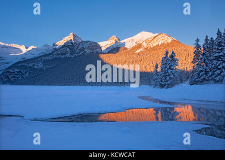 Sunrise reflection of the Canadian Rocky Mountains at Lake Louise, Banff National Park, Alberta, Canada Stock Photo