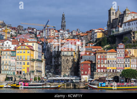 Row of buildings on the Douro riverfront in Porto city, Portugal. View with bell tower of Clerigos Church Stock Photo