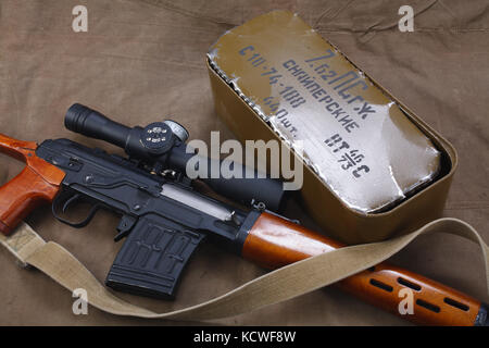 SVD sniper rifle with box of ammunition on canvas background. The inscription translates as 'Snipers Ammunitions' Stock Photo