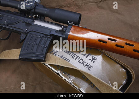 SVD sniper rifle with box of ammunition on canvas background. The inscription translates as 'Snipers Ammunitions' Stock Photo