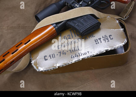 SVD sniper rifle with box of ammunition on canvas background. The inscription translates as 'Snipers Ammunitions' Stock Photo