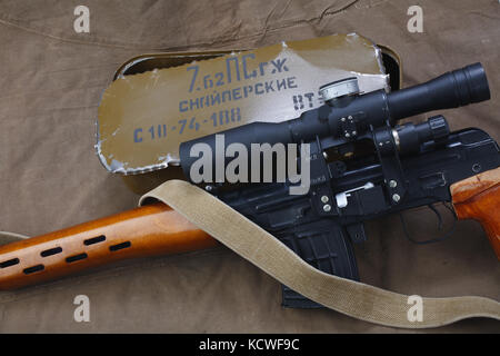 SVD sniper rifle with box of ammunition on canvas background. The inscription translates as 'Snipers Ammunitions' Stock Photo