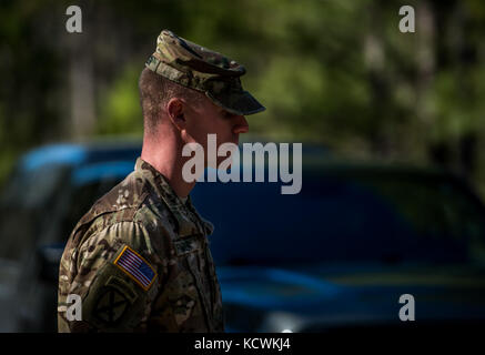 South Carolina Army National Guard testing proctor wait for participants to cross the 7.5 mile marker during a ruck march at the Best Warrior Competition on McCrady Training Center in Eastover, S.C., Jan. 29, 2017. The five-day event consisted of challenges that tested the participants’ knowledge, skills and perseverance. Events included a road march, physical fitness test and weapons qualification. The 2017 competition was also the first time the German Armed Forces Badge for Military Proficiency tryouts were incorporated into the competition. (U.S. Air Force photo by Staff Sgt. Marianique Sa Stock Photo