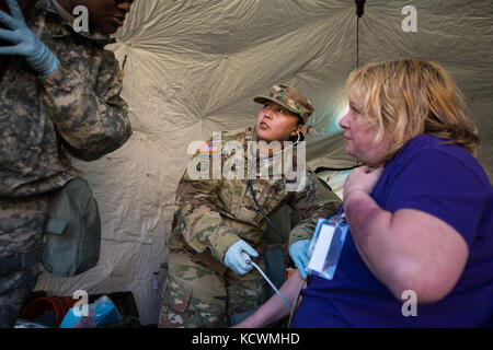 U.S. Army Sgt. Jasmyne Hustito, medic assigned to the 251st Area Support Medical Company, South Carolina Army National Guard, takes a patient’s vitals during a joint training exercise at Camp Fretterd, Reisterstown, Maryland, March 8, 2017.  The 251st along with the 231st Chemical Company from the Maryland Army National Guard are participating in an U.S. Army North validation exercise where they will be setting up a full medical area and completing triage at the casualty collection point. (U.S. Air National Guard photo by Tech. Sgt. Jorge Intriago) Stock Photo