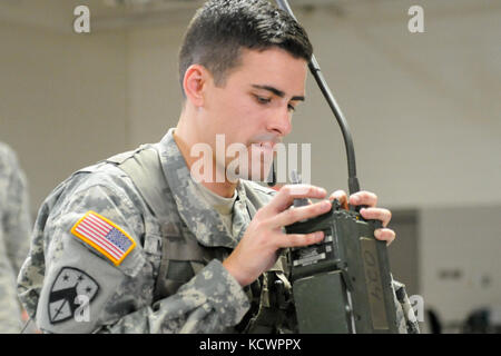 U.S. Army Sgt. Brandon McCarty, 1st Battalion 118th Infantry Regiment, 218th Maneuver Enhancement Brigade, South Carolina National Guard, assembles and programs a radio during the battalion-level Best Warrior Competition in North Charleston, South Carolina, Oct. 23, 2016.  The selection board for the competition consisted of four voting members evaluating candidates' skills and knowledge in areas such as the Army Physical Fitness Test, land navigation, self-aid and buddy care, Army programs and current events. One Soldier and one non-commissioned officer, along with an alternate for each, will Stock Photo