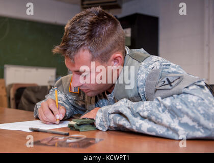 U.S. Army Spc. Jackson Pride, Alpha Co., 1st Battalion, 118th Infantry Regiment, 218th Maneuver Enhancement Brigade, South Carolina National Guard, takes a written exam to evaluate land navigation skills in North Charleston, South Carolina, Oct. 23, 2016, as part of the battalion-level Best Warrior Competition. The selection board for the competition consisted of four voting members evaluating candidates' skills and knowledge in areas such as the Army Physical Fitness Test, land navigation, self-aid and buddy care, Army programs and current events. One Soldier and one non-commissioned officer, Stock Photo