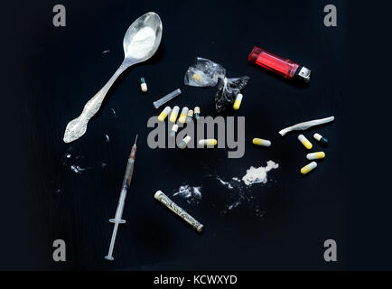 Drug syringe and cooked heroin. Various substances causing dependence. Problems with drugs concept. Top view Stock Photo