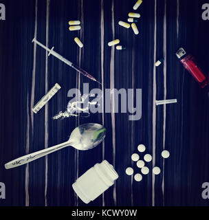 Drugs on the table photo toned in retro style. Spoon which is white powder there are different types of drugs. Stock Photo