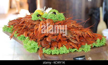 Seafood lobsters. Crabs tentacles on big plate with green salad Stock Photo