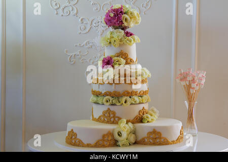 Big white wedding cake with flowers and ornaments Stock Photo
