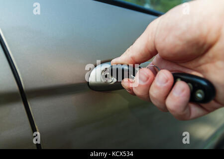 man's hand opens the car door with a key. Stock Photo