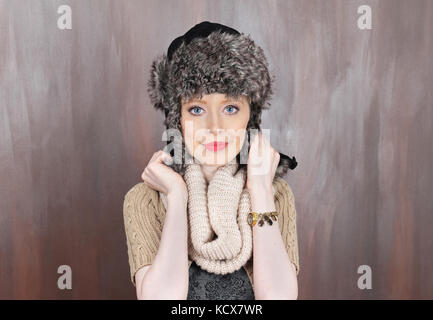 Young beautiful blue eyed girl wearing traditional warm Russian cap with ear flaps Stock Photo