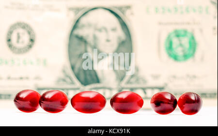 picture of a Cod liver oil omega 3 gel capsules in front of one dollar bill Stock Photo