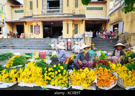 Flower vendors at the Hoi An market in Hoi An Ancient Town, Quang Nam, Vietnam. Hoi An is recognized as a World Heritage Site by UNESCO. Stock Photo