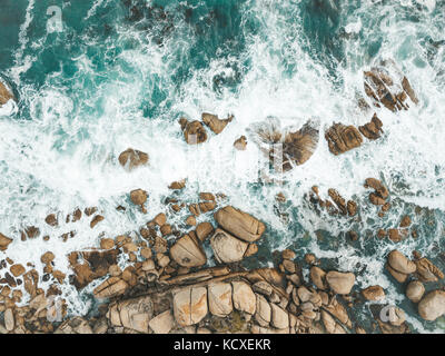 Atlantic Ocean waves crashing into the boulders of South Africa's Maidens Cove in Cape Town. Stock Photo