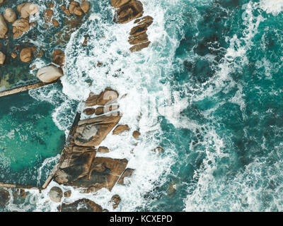 Atlantic Ocean waves crashing into the boulders of South Africa's Maidens Cove in Cape Town. Stock Photo