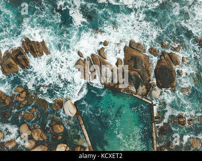 Atlantic Ocean waves crashing into the boulders of South Africa's Maidens Cove in Cape Town. Stock Photo