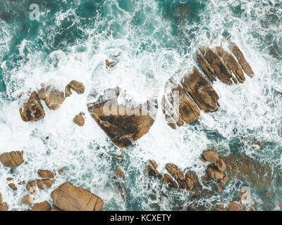 Atlantic Ocean waves crashing into the boulders of South Africa's Maidens Cove in Cape Town. Stock Photo