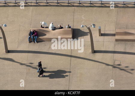 Street scene of Blackpool sea front. Couples walking and resting on a bench. Credit Lee Ramsden / Alamy Stock Photo