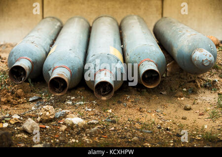 Five empty gas bottles laying on ground Stock Photo