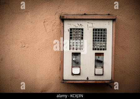 Old chewing gum vending machine on a wall Stock Photo