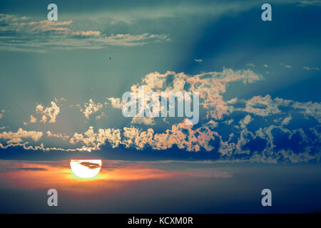 Dramatic cloudscape, sun setting through clouds Stock Photo