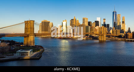 Sunrise on the Brooklyn Bridge, the East River and the skyscrapers of Lower Manhattan (panoramic). New York City Stock Photo