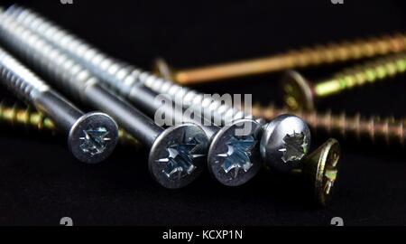 Abstract cross-head or Phillips-head or recessed-head screw on black Background, Stock Photo