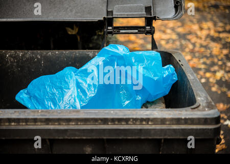 Open trash bin with blue plastic bag Stock Photo